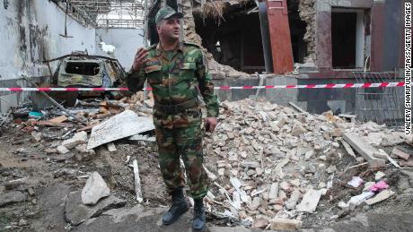 In Gyandzha in Aserbaidschan steht ein Soldat vor einem Gebäude, das angeblich durch Granaten beschädigt wurde.