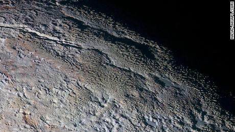 Pluto&#39;s snow-capped mountains look like they belong on Earth, 但是他们&#39;re entirely different