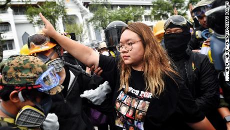 Protest leader Panusaya &quot;Rung&quot; Sithijirawattanakul (C) makes the three-fingered Hunger Games salute during a pro-democracy rally in Bangkok on September 20, 2020. 