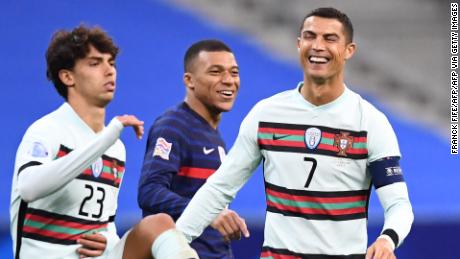 Ronaldo (right) shares a joke with French striker Kylian Mbappe (center) during Portugal's Nations League match. 