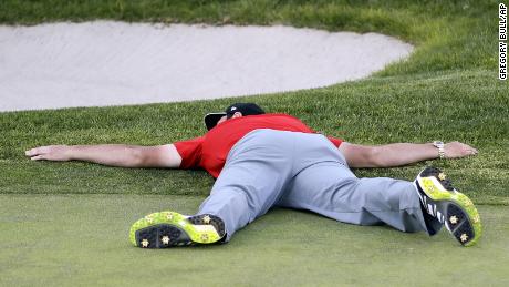 Rahm lies on the green of the 18th hole after winning the Farmers Insurance Open in 2017.
