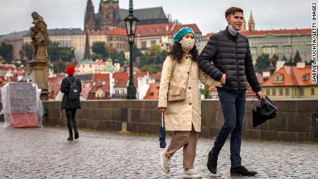 Tourists walk across Prague&#39;s medieval Charles Bridge as the Czech Republic faces a record spike after previously keeping numbers low.