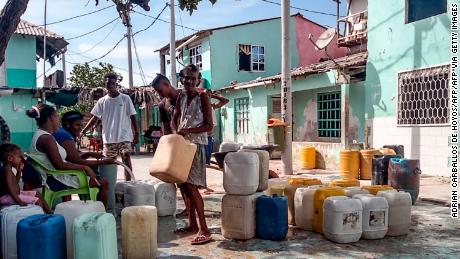 Inhabitants carry buckets of water in a street at Santa Cruz del Islote island, located in the Colombian Caribbean, off the coast of Sucre Department, on June 17, 2020, during the COVID-19 pandemic. - The coronavirus pandemic exposed poverty and state neglect in the most densely populated island in Colombia -a place where social distancing is almost impossible. (Photo by Adrian CARBALLOS De HOYOS / AFP) (Photo by ADRIAN CARBALLOS DE HOYOS/AFP via Getty Images)