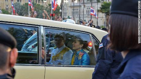 Thailand&#39;s Queen Suthida (C) and Prince Dipangkorn Rasmijoti (centre L) react inside a royal motorcade as it drives past a pro-democracy rally in Bangkok on October 14, 2020. 