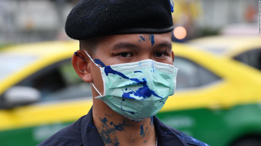 파란색 페인트, 민주화 시위대에 의해 시위 중에 던져, 경찰관에게 흩 뿌려진 모습, 그는 왕실의 자동차가 지나갈 때까지 경비를 서서, 10 월 방콕에서 13.