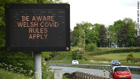 Ein Schild, das Reisende auffordert, die Covid-19-Regeln von Wales einzuhalten, wird am 16. Mai 2020 neben der Autobahn A55 in der Nähe von Flint, Nordwales, angezeigt, nachdem die Sperrregeln in England während der neuartigen Coronavirus-COVID-19-Pandemie gelockert wurden. - Die Leute werden darum gebeten 