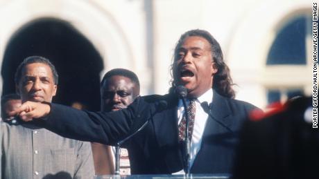 Reverend Al Sharpton speaks to the crowd while a member of the Nation of Islam stands guard at the Million Man March October 16, 1995 en Washington, corriente continua. 