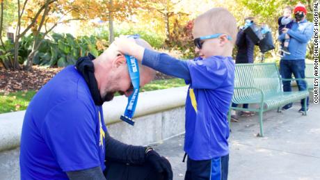 Kolt Codner&#39;s son awards him with a medal after completing his marathon to raise money for Akron Children&#39;s Hospital.