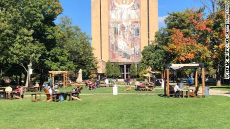 Students sit outside and take a break between classes on the campus of Notre Dame University in South Bend, Indiana on October 6, 2020.