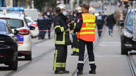 French policemen and firefighters stand guard after the attack in Nice on October 29.