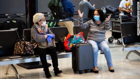Passengers wear protective face masks while talking in Brazil&#39;s São Paulo/Guarulhos International Airport on March 15.
