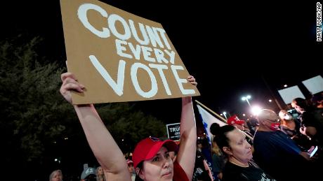 A supporter of President Donald Trump holds a &quot;Count every vote&quot; sign at a rally Wednesday night outside the Maricopa County vote counting center in Phoenix.