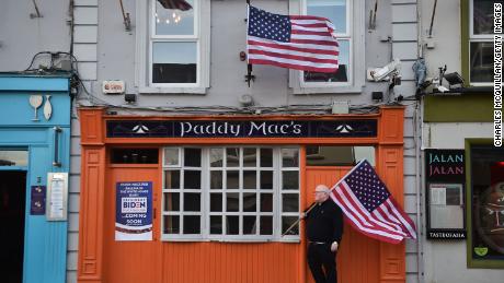 Paddy Macs bar owner Michael Carr stands outside his pub with an American flag on November 7, 2020. 