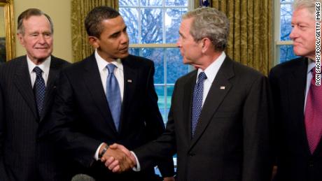 In this January 7, 2009, ファイル写真, ジョージW大統領. Bush shakes hands in the Oval Office with President-elect Barack Obama as former Presidents Bill Clinton and George H.W. Bush look on.