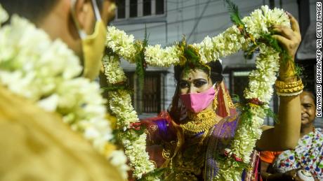 A bride exchanges flower garlands with a groom as part of their traditional marriage ceremony in Kolkata in July, 2020.