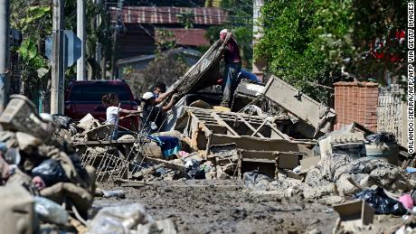 People try to recover belongings amid mud after the passage of Hurricane Eta as they prepare to evacuate the Omonita neighborhood in El Progreso, Yoro department, Honduras.