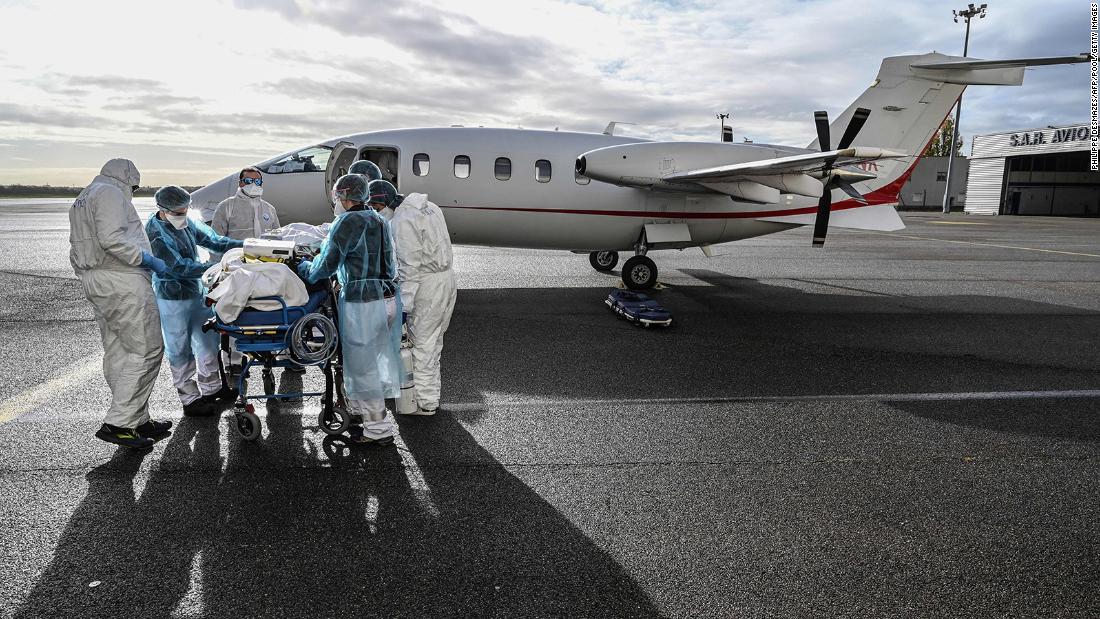 Medical staff transport a coronavirus patient to a waiting flight at the Lyon-Bron Airport in France on November 16.