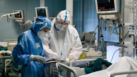 Ärzte mit persönlicher Schutzausrüstung arbeiten mit einem Patienten in einer temporären medizinischen Einrichtung für Covid-19-Patienten in Moskau, Russland.