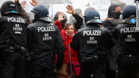 Demonstrators put up their hands in front of police officers during a protest against the government&#39;s coronavirus restrictions in Berlin, noviembre 18, 2020.