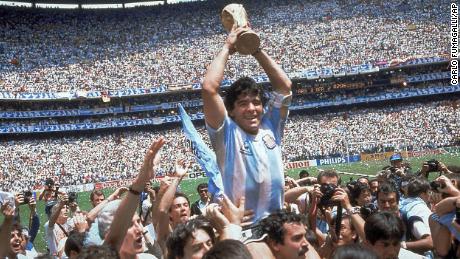 FILE - In this June 29, 1986 file photo, Diego Maradona holds up his team&#39;s trophy after Argentina&#39;s 3-2 victory over West Germany at the World Cup final soccer match at Atzeca Stadium in Mexico City. The Argentine soccer great who was among the best players ever and who led his country to the 1986 World Cup title before later struggling with cocaine use and obesity, died from a heart attack on Wednesday, Nov. 25, 2020, at his home in Buenos Aires. He was 60. (AP Photo/Carlo Fumagalli, File)