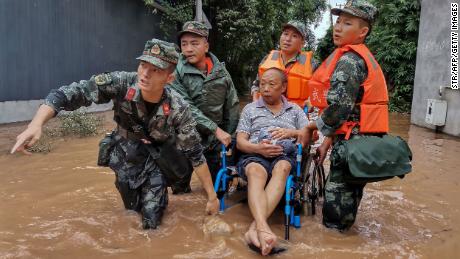Un residente es evacuado de una calle inundada en Meishan, en la provincia de Sichuan, suroeste de China.