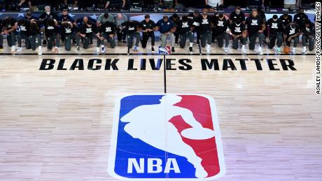 Mitglieder der New Orleans Pelicans und des Utah Jazz knien vor dem Start ihres Spiels im HP Field House im ESPN Wide World Of Sports Complex am 30. Juli 2020 in Reunion, Florida, vor einem Black Lives Matter-Logo. 