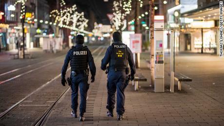 Police officers walk in an empty pedestrian shopping street on December 8 in Mannheim, one of  several German cities to have imposed a post-9 p.m. aandklok.