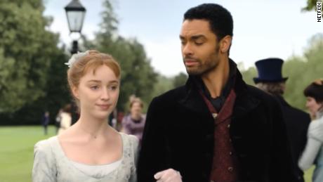 Phoebe Dynevor (left) and Regé-Jean Page (right) are shown in a scene from &quot;Bridgerton,&quot; which has been a huge hit for Netflix.