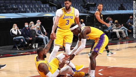 Anthony Davis and Kostas Antetokounmpo help up teammate James during the game against the Memphis Grizzlies.