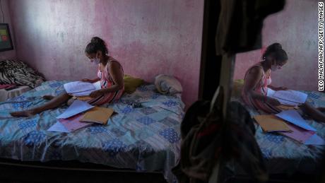 Student Gloria Dayane prepares to do her homework on a printout version of a textbook in Camaragibe, Pernambuco state, Brazil, on July 25, 2020.