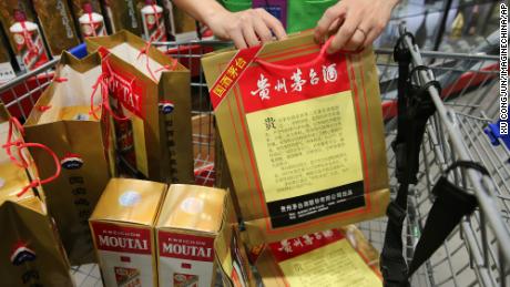 Ein Mitarbeiter zeigt Chinas führenden Spirituosenhersteller Kweichow Moutai 2018 in einem Supermarkt in der Stadt Nantong in der chinesischen Provinz Jiangsu.