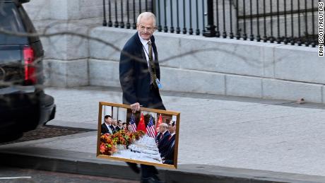 White House advisor Peter Navarro leaves the West Wing of the White House with a photograph of U.S. President Donald Trump and Chinese President Xi Jinping, ワシントンで, 我ら。, 1月 13, 2021. 