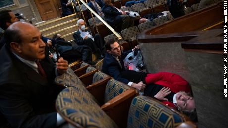 Rep. Jason Crow, a Colorado Democrat, comforts Rep. Susan Wild, a Pennsylvania Democrat, while taking cover as rioters seiged the US Capitol on January 6.