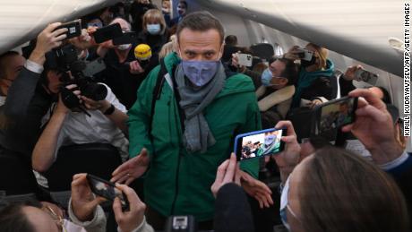 Passagiere und Journalisten fotografieren Alexey Navalny, als er am Sonntag seinen Platz auf dem Flug einnimmt.