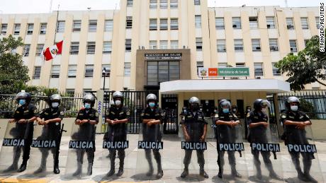 La policía monta guardia frente al Ministerio de Salud mientras los trabajadores de la salud protestan en Perú el 13 de enero.