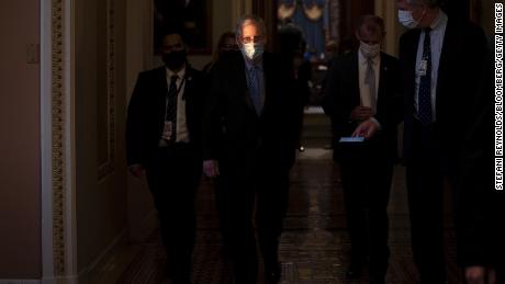 Senate Minority Leader Mitch McConnell, center, wears a protective mask while walking to his office from the Senate Chamber at the U.S. Capitol in Washington, D.C., U.S., on Thursday, Jan. 21, 2021.