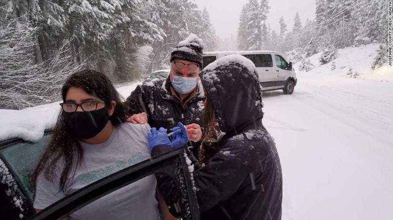Health workers, stuck in the snow, administer coronavirus vaccine to stranded drivers