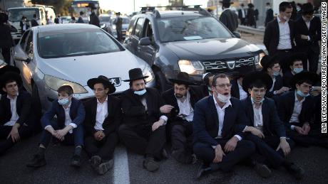 Los judíos ultraortodoxos bloquean una carretera en Bnei Brak durante una manifestación organizada momentos antes de que Israel entrara en un tercer cierre nacional el 27 de diciembre.