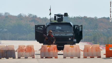 A soldier stands guard on a blockaded road to Myanmar&#39;s parliament in Naypyidaw on February 1, 2021, after the military detained the country&#39;s de facto leader Aung San Suu Kyi and the country&#39;s president in a coup. 