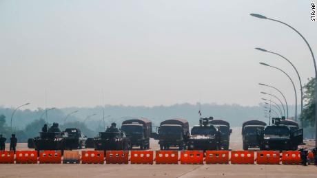 Myanmars militärischer Wachmann an einem Kontrollpunkt, der mit gepanzerten Fahrzeugen besetzt ist und eine Straße blockiert, die zum Parlamentsgebäude am 2. Februar 2021 in Naypyidaw, Myanmar, führt. 