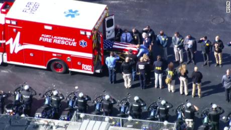 A body draped in an American flag is transported from an ambulance following the fatal shooting of two FBI agents in Sunrise, Florida, on Tuesday. 