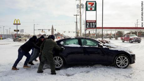 People work to free a stuck motorist in Oklahoma City on February 15, 2021.