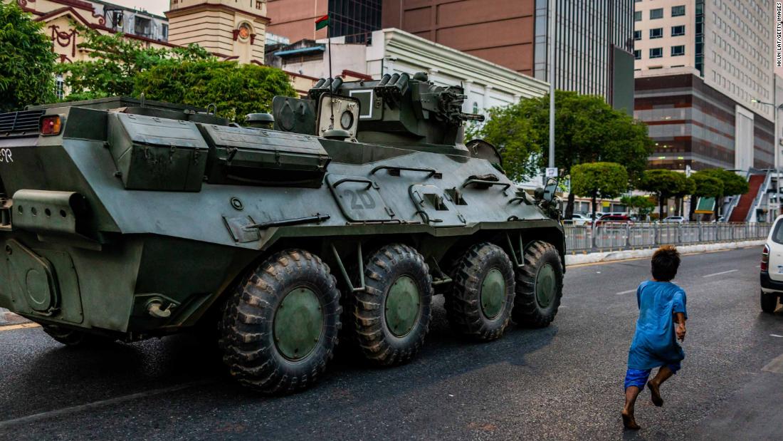 A child runs alongside an armored vehicle in Yangon on February 14.