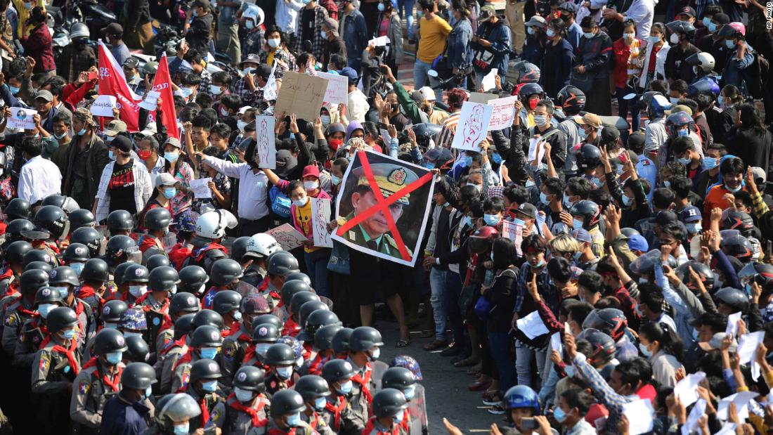 Protesters flash three-fingered salutes as they face rows of riot police in Naypyidaw on February 8.