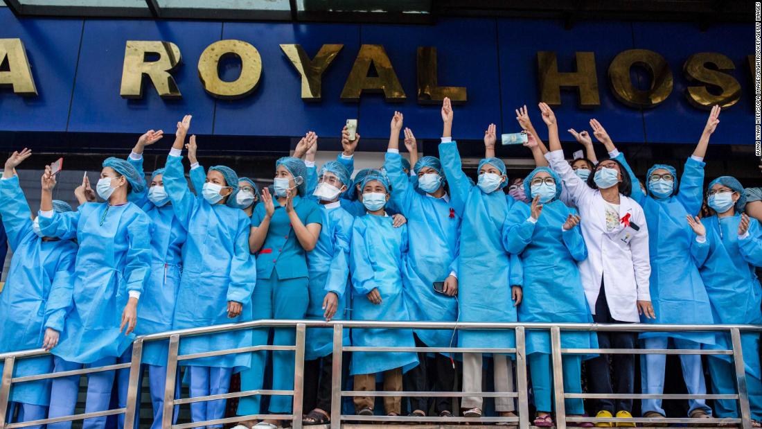 Hospital workers show three-finger salutes during a demonstration in Yangon on February 7.