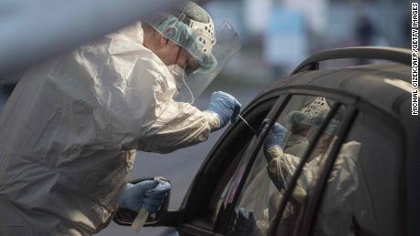 Ein medizinischer Mitarbeiter entnimmt einer Person an der Drive-In-Coronavirus-Teststation in Prag eine Probe.