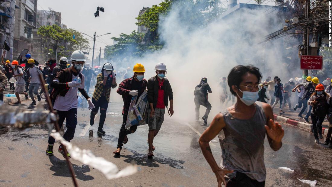 Protesters in Yangon run away from tear gas on March 1.