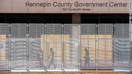 Workers install security fencing at the Hennepin County Government Headquarters in Minneapolis, Minnesota, on March 3, 2021.