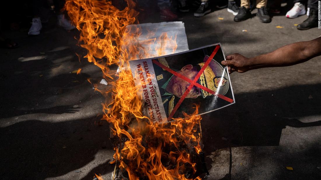 A citizen of Myanmar living in India burns a poster of Myanmar&#39;s military chief during a protest in New Delhi on March 3.