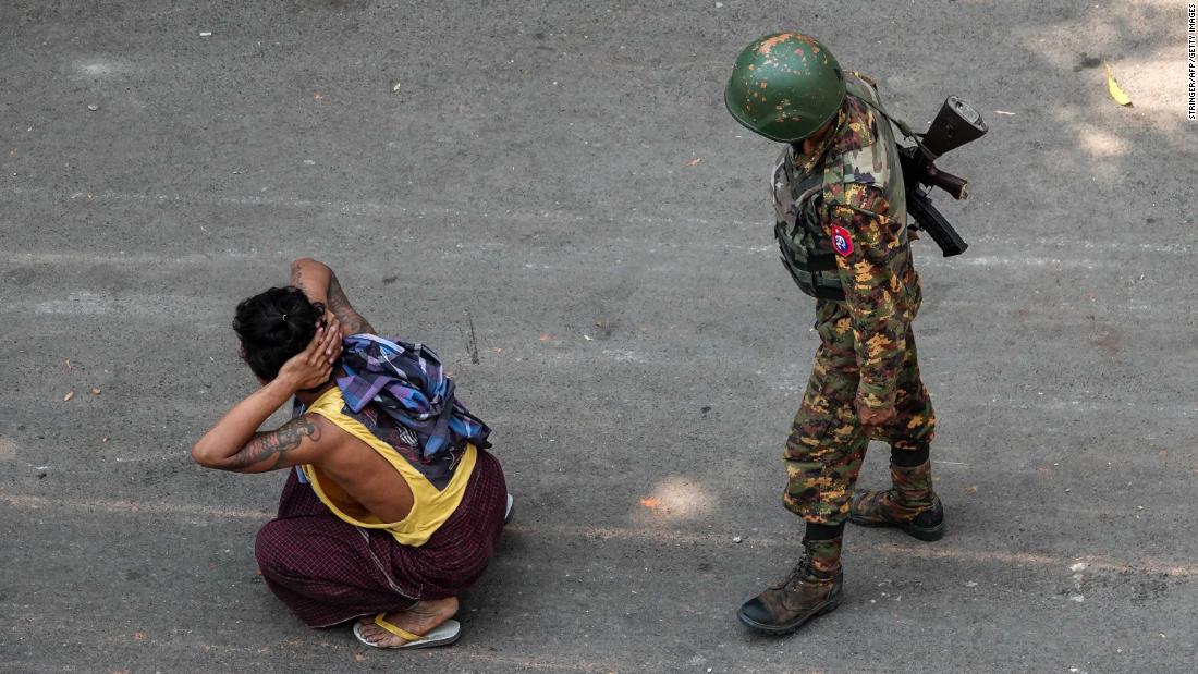 A soldier stands next to a detained man during a demonstration in Mandalay on March 3.